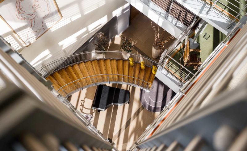 Blick vom Treppenhaus nach unten auf einen Klavierflügel im Hotel Neuruppin
