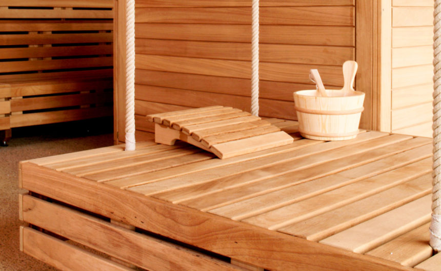 Hängende Holzliege mit Kopfstütze und Holzbottich in der Sauna der Therme Brandenburg.