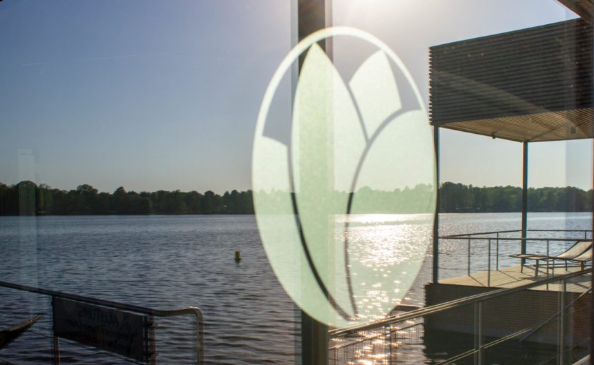 Blick durch die Glasscheibe der Therme Brandenburg auf den See